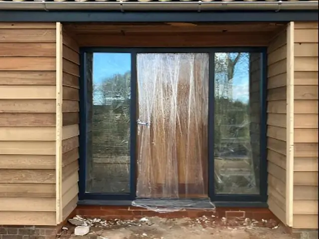 Sliding doors installed in a cedar-clad gable